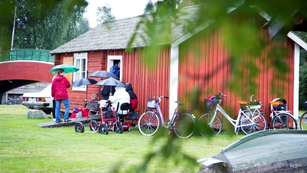 Alla fick inte plats så några fick nöja sig med att lyssna under sina paraplyer utanför stugan.