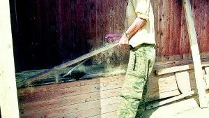 Åke Rosdahl sliter ut det gamla dasset i Klockargården. Praktiskt byggjobb.