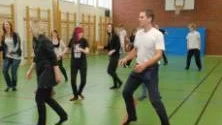 Övning ger färdighet. idrottsläraren Andreas har lärt ut stegen och nu är det full fart till musik som gäller. Ett par modiga föräldrar vågade sig upp på dansgolvet och bjuder på lite line dance. Foto: Lillemor Molin