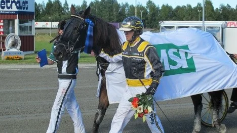 Kusken och tränaren Petter Lundberg i segermarsch med Vitsandsägde travaren Pompano efter segern i V75-4.