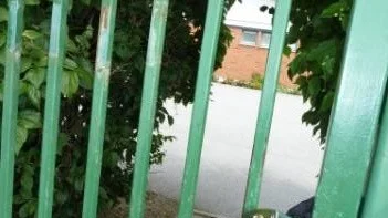 "Grinden ska vara stängd" står på koloniföreningens skylt i Pryssgården. Nu är den även låst, via ett ditsatt hänglås av Norrköpings kommun.I bakgrunden skymtar det inblandade gruppboendet Fiskebyvägen 10.