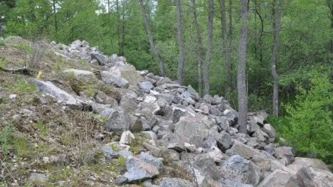 Parkeringen bakom gamla Margarethahemmet i Knivsta är ett olovligt bygge där sprängmassor har tippats i skogen.
