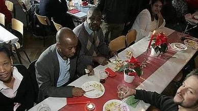 Elisatbeth Addis och Alberto Perea, längst fram, äter julmat med vänner.