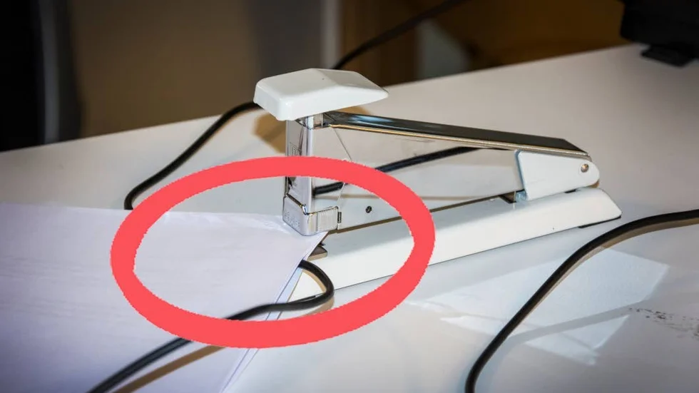 En kabel till en högtalare hamnade i kläm när några papper skulle häftas samman. Det ledde till kortslutning, företagets datorer slogs ut och produktionen lades ned.
