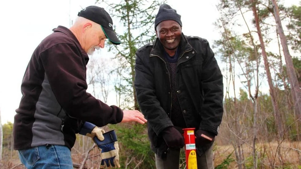 William Libusi planterar symboliska granplantor under sitt besök i Östhammar. Här tillsammans med Hans Tibell.