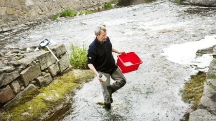 Lars Eriksson från SLU, tar prover på Fyrisåns vatten.