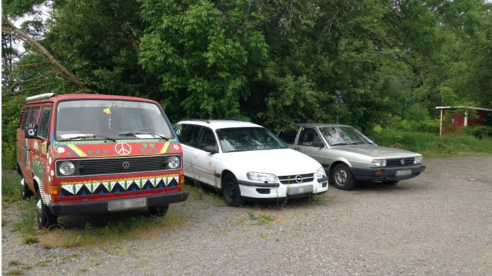 Tre övergivna bilar finns på parkeringsplatsen.
