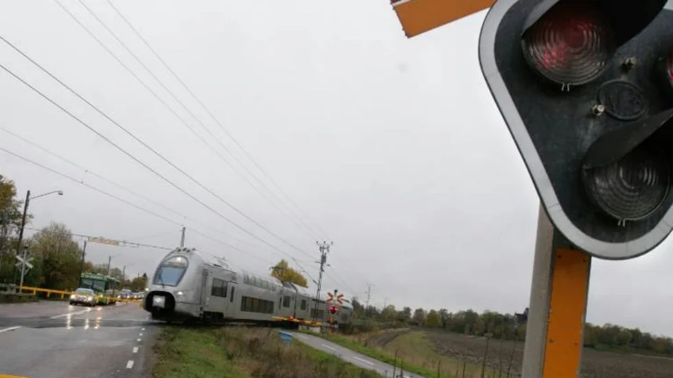UPPSALA 20061023
Ett dubbeldäckartåg på väg till Uppsala passerar en järnvägsövergång med fällda vägbommar och varningslampor.
Foto Fredrik Sandberg / SCANPIX / Kod 10180
