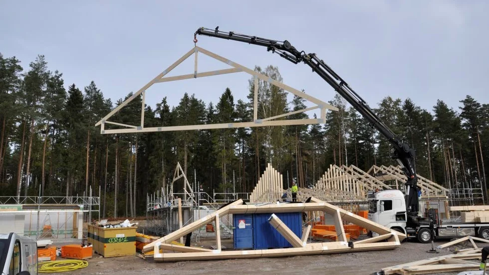 Kranföraren Mattias Sjökvist lyfter takstol efter takstol vid bygget av Prästgårdsbacken i Alunda.