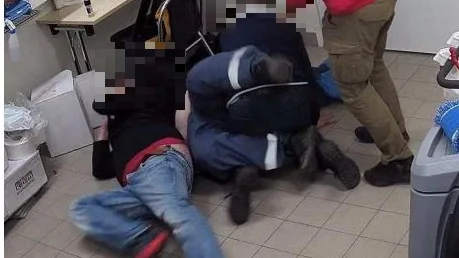 När väktarna ska kroppsvisitera mannen efter att han snattat en glass uppstår tumult i vaktrummet.