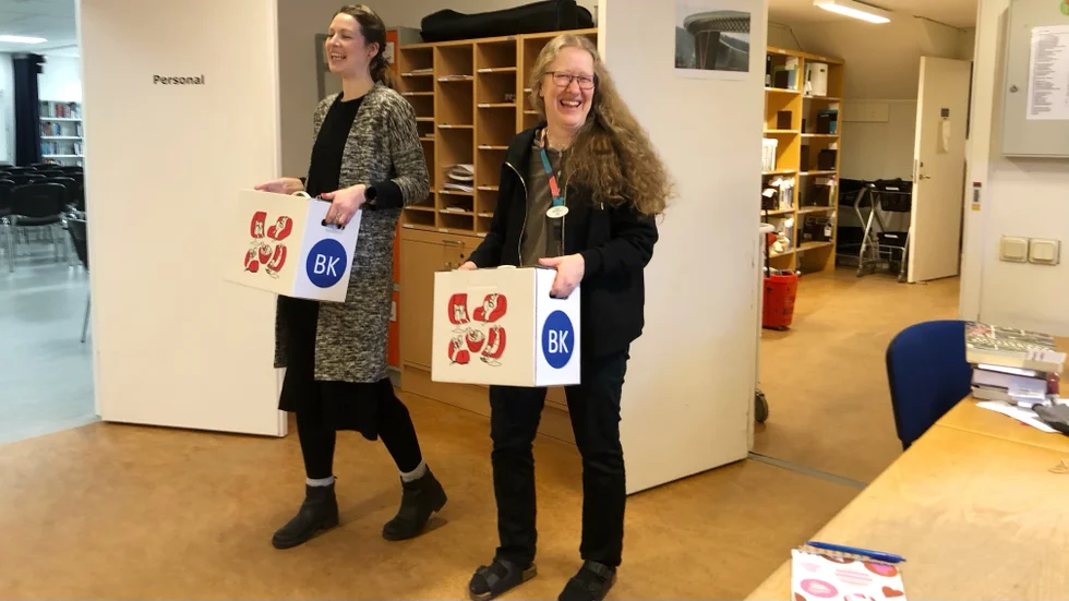 Sandra Jonsson och Inger Hollström Flis bär fram boklådorna som ska levereras.