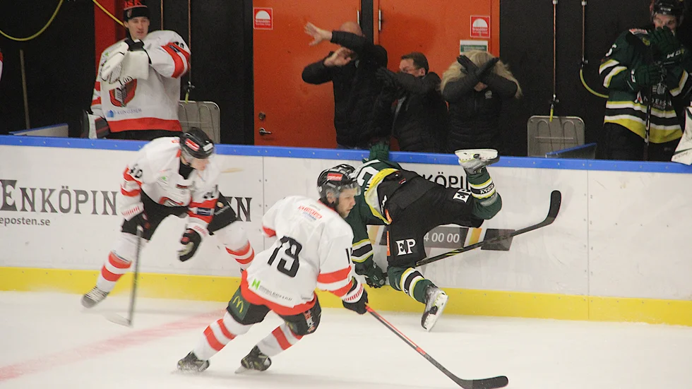 Delar av ESK-staben i båset gör tydliga tecken till domarteamet att agera när Edvin Günther fälls över ända. Eller tar de skydd mot förlupna puckar?