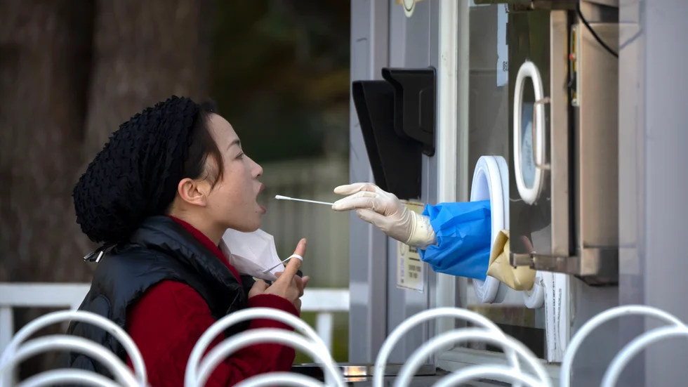 En kvinna blir testad för covid-19 i Peking. Landets hårda nolltolerans med nedstängningar och restriktioner kan ha lett till att en treårig pojke dog. Arkivbild