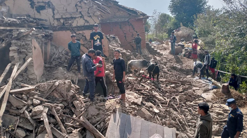 Bybor i en by i Dotidistriktet i Nepal betraktar skadorna efter skalvet.