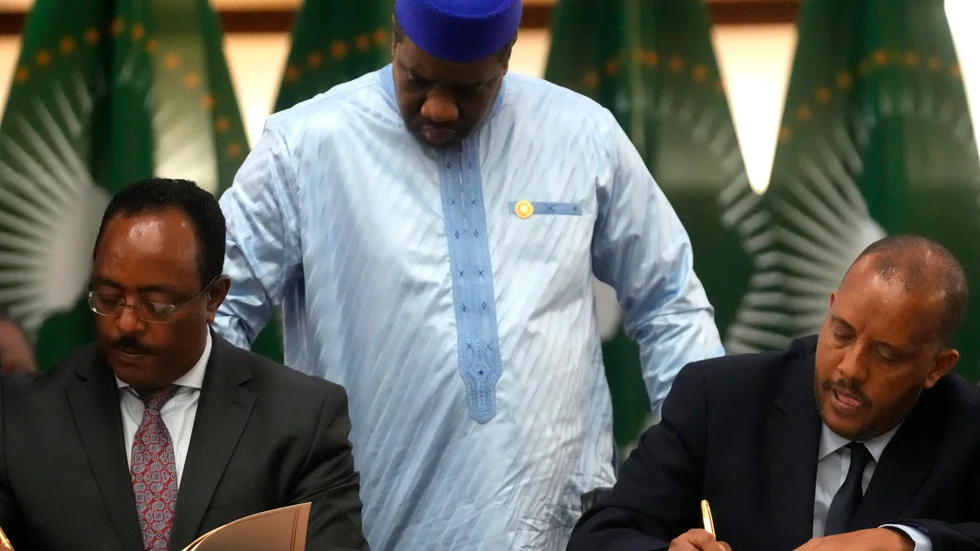 Regeringens förhandlare Redwan Hussein och Tigrayrebellernas förhandlare Getachew Reda under förra veckans samtal i Pretoria. Bakom dem Alhaji Sarjoh Bah från Afrikanska unionen.