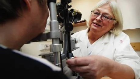 Kerstin Lahi, verksamhetschef vid ögonkliniken, vid ett ögonmikroskop.