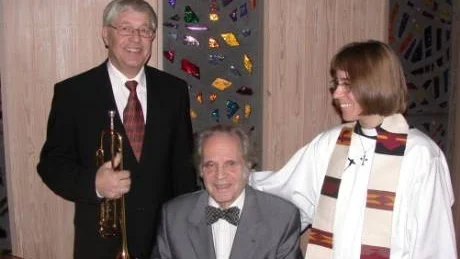 Solister. Rune Elmehed vid Sankt Andreaskapellets piano, omgiven av trumpetsolisten Christer Gyllenstrand och julottans sångsolist, församlingens präst Jennifer Rydqvist.Foto: Rune Engelbrektson