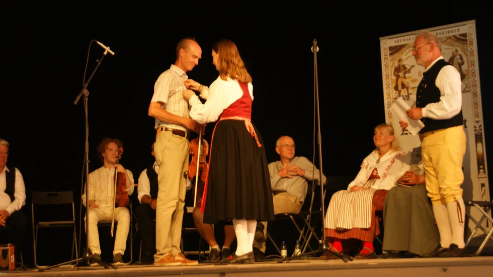 Zornmärkesnämndens ordförande Elin Anderzon överräcker silvermärket och diplomet till Nyköpingsbon Henrik Lindberg. 