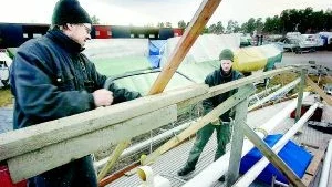 Vinterskydd. Roger Ulvbane och Carl Oscarsson är uppe på däck för att bygga en ordentlig ställning för kommande vintertäckning av Maribell.Foto: ANDERS LILJEGREN
