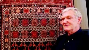 Mattexpert. Jan-Inge Bengtsson, tidigare ordförande i Svenska Afghanistankommittén, höll ett mycket intressant föredrag om afghanska mattor på Gamleby folkhögskola i går. Han poserar framför en matta gjord i "soumakteknik" eller "snärjväv", en teknik som använts även i Norden. FOTO: HANS BRANDIN