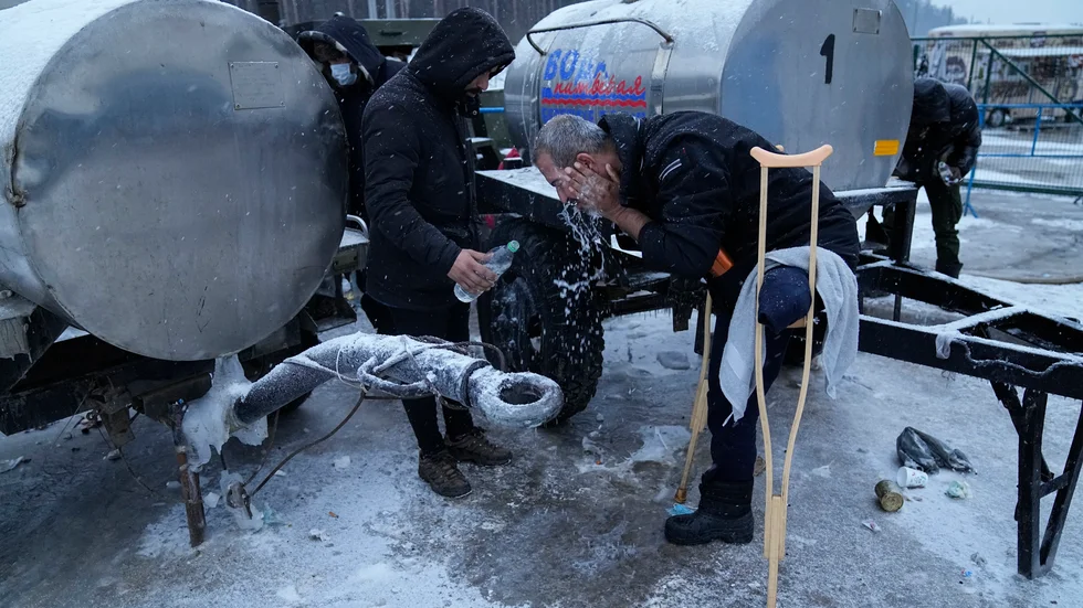 En migrant i Belarus tvättar ansiktet vid ett logistikcenter nära gränsen mot Polen.Arkivbild.