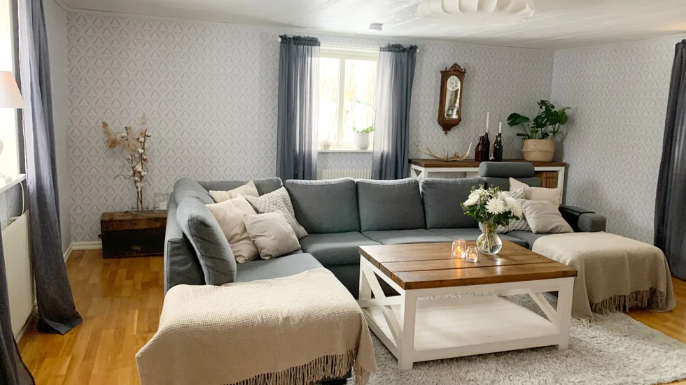 Vardagsrummet är ljust och tapetserades när paret flyttat in i huset 2019. 