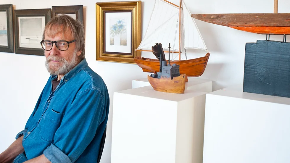 Tre former. Ingemar Nilsson bredvid tre båtar som representerar hantverk, konsthantverk och konst. Tre områden han jobbar inom. Foto: Emilie Sjölund.