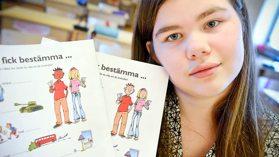 Skillnad. Hanna Berggren håller upp det ändrade seriealbumet till vänster och det gamla till höger. Tack vare henne ändrade riksdagen på sitt studiematerial för skolorna. Foto: Leif Andersson.