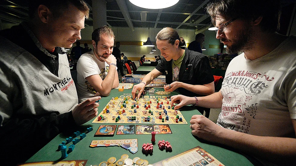 SPELAR FIVE TRIBES Till vänster: Skellefteåkillarna Mikael Holmstrand och David Burman spelar brädspelet Five Tribes: The Djinns of Nagala mot Thomas Engström (längst bort på högersidan) och Peter Lundström, Skellefteå. Foto: Annika Eriksson.