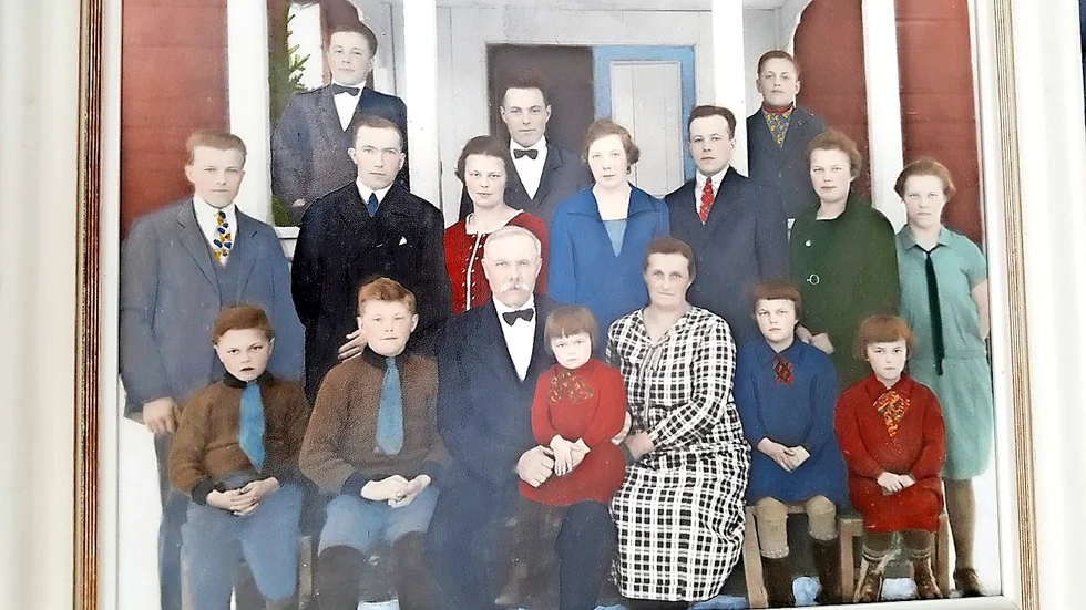 Fromheden 1928: Uppe på farstubron står ynglingarna Arvid och Alexander med äldsta brodern John i mitten. Raden framför: Ragnar, Alfred Lundgren, fästman till Jenny, Astrid Ask, fästmö till Knut (Astrid och Knut gifte sig 1928), Maja och Anna. Främre raden: Emil, Lasse, Per med 3-åriga Gunborg i knäet, Selma, Edit och Judit.
