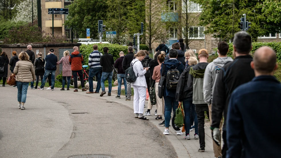 Kön ringlar sig lång med personer som är ute efter ännu en dos vaccin mot covid.
