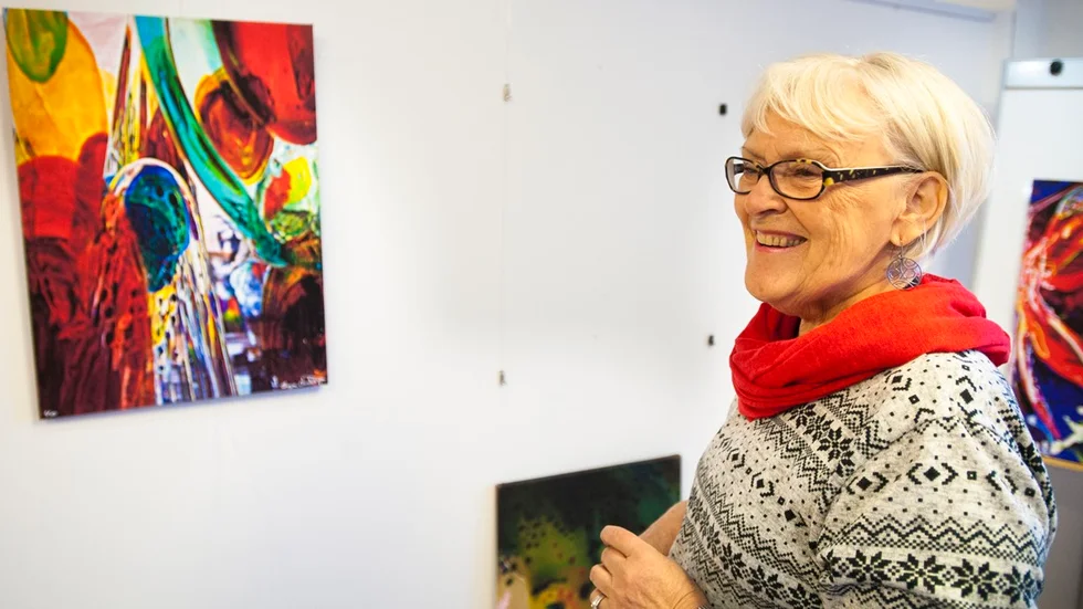 Inger Lundström bredvid tavlan "På vandring". "Jag tänkte på flyktingarna och hur de tvingas lämna sina hem", säger hon. Foto: Emilie Sjölund.