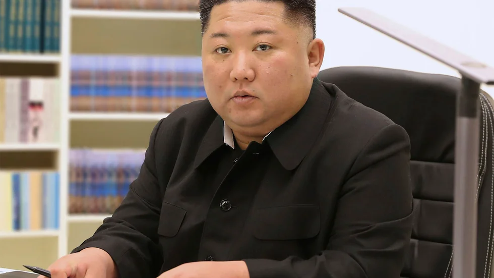 Nordkoreas diktator Kim Jong-Un med sitt nyårsbrev. Bilden kommer från den statliga nyhetsbyrån KCNA.