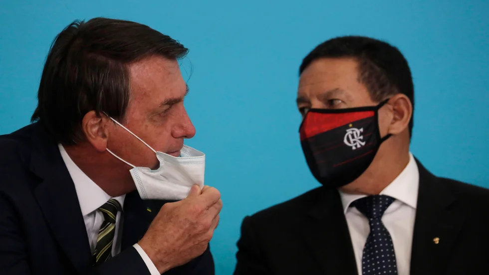 Brasiliens president Jair Bolsonaro i samspråk med vicepresident Hamilton Mourão vid en ceremoni i presidentpalatset i Brasília i fredags.