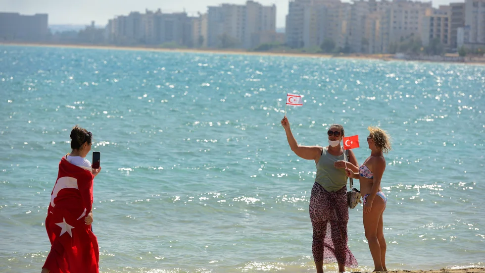 Strandbesökare i Varosha hade med sig turkiska och turkcypriotiska flaggor, sedan soldaterna släppt in dem i det övergivna turistområdet. Bild från förra veckan.