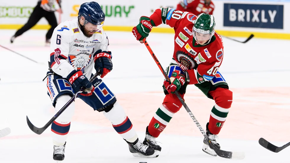 Jonas Holös i kamp om pucken med Joel Mustonen. 