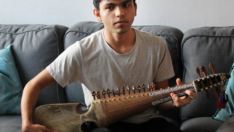 Spelar rubab. Hasibullah Faizi kommer från Afghanistan.