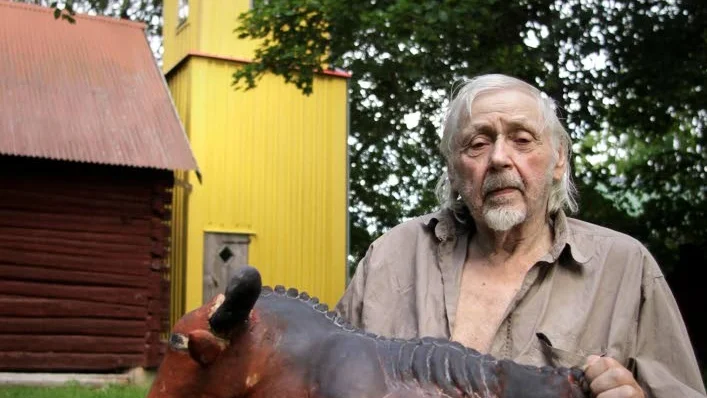 Arne Fälth med skulpturversionen av Sommakoa framför sitt torn i Ekeby.