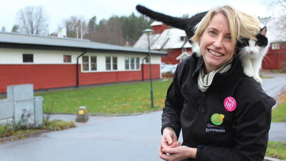 Sofie Alvarsson, rektor för Gamlebygymnasiet, med en okänd katt, som hälsar på ibland.