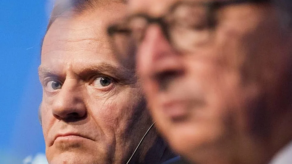 Ilsken. Donald Tusk ger Jean-Claude Juncker en sur blick.