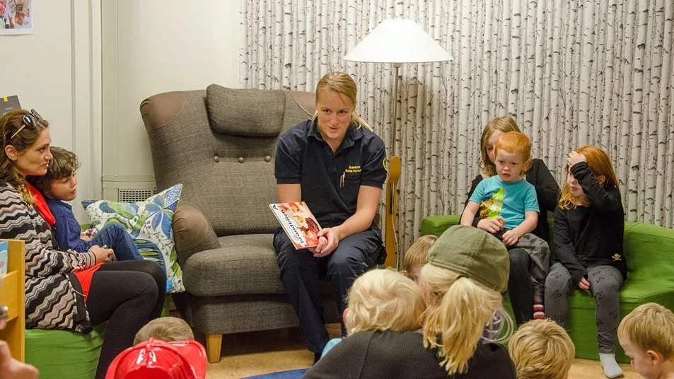 Trängsel i sagohörnan när brandkåren läser sagor.