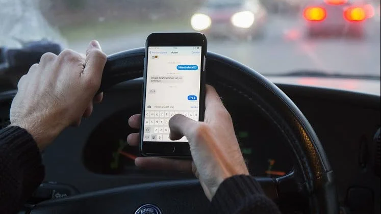 En 59-årig man måste böta 1 500 kronor för att han kört bil och pratat i mobiltelefon samtidigt.