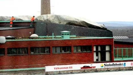 Byggnadsarbetare från ett entreprenörsföretag började genast att arbeta med det uppfläkta taket på simhallen i Kiruna. Första åtgärden var att se till att se till taket inte blåste ned helt och hållet. FOTO: Hans Sternlund