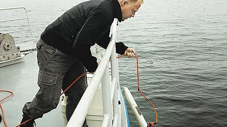 Jens Lindström kastar i sonarfisken med vilken botten av Brändöfjärden skannades av. FOTO: Elisabeth Hedman