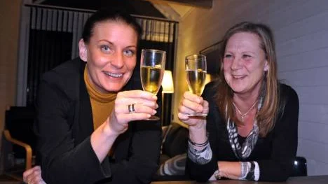 Linda Frohm och Ewa Hietala skålar i den första Kalixstugan som står alldeles vid älvens kant.<_Bildtext Fotobyline>FOTO: Lotta Nilsson</_Bildtext Fotobyline>