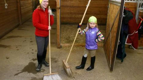 Inga-Maria Stoor och Tyra, 6 år, hjälptes åt att sopa i båsen.