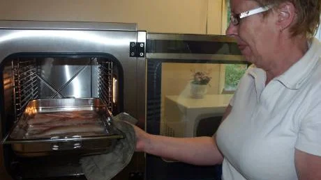 Lena Eriksson sätter in fiskfiléerna i ugnen och hoppas att barnen ska tycka om maten.