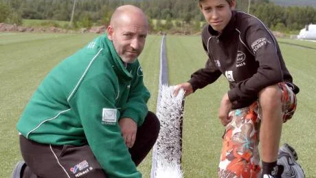 De vita linjerna fälls in i konstgräsplanen. Mikael Selini och sonen David visar hur det går till.