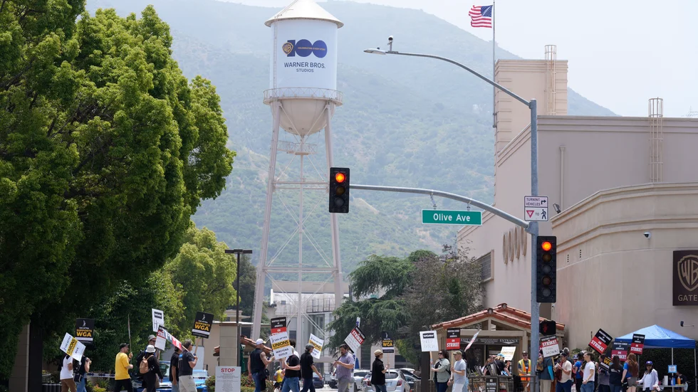 Strejkande manusförfattare utanför Warner Bros. Studios i Burbank, Los Angeles i maj. Ett nytt kontrakt mellan filmbolagen och regissörsfacket kan leda till en väg ur strejken. Arkivbild.
