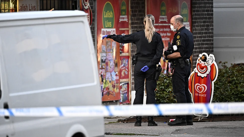 Polis och kriminaltekniker på plats utanför den närlivsbutik i Landskrona där en man i 20-årsåldern blev ihjälskjuten på söndagen. Arkivbild.